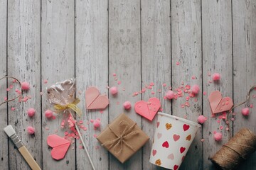 Flat lay Happy Valentine's Day photography with gift box and paper origami heart on wooden background. Romantic greeting card. 