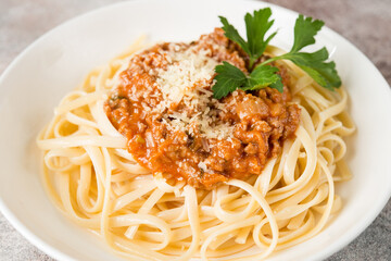 Traditional Italian pasta with bolognese sauce in a white plate