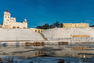 An old building in the city on a hill on the riverbank in winter. Restoration of the old castle. Monument of architecture and historical heritage.