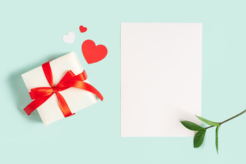 Desktop blank paper note pad. Flat lay of blue working table background with Valentine gift, letter, heart shape and decoration. Top view, mock up greeting card