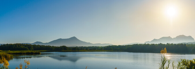 Panorama of the sunrise in the morning with mountain, lake and sky at Mae Mo, Lampang, Thailand.