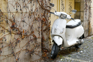 Motorcycle parked on the street in front of the house, covered with snow in winter