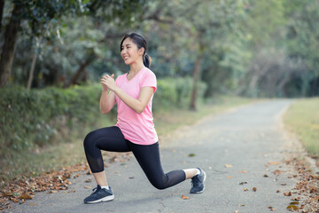 Asian girl is stretching her body warm muscles before going out for a run at the park