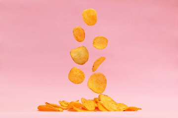 Potato chips fly on a pink background. Levitation. Snacks