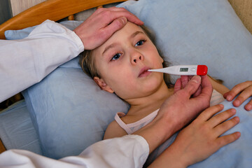 Sick child, toddler girl lying in bed with a fever, resting at home. Illness child. Girl measuring...