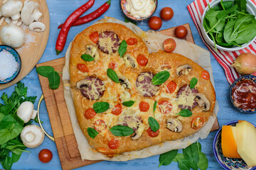 Homemade pizza for Valentine's Day.Delicious pizza heart made of yeast-free dough with healthy vegetables, tomatoes, herbs and cheese, prepared at home for a festive dinner