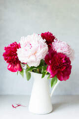 Vase with bouquet of beautiful peonies on table in room, close-up. Bloom. Peony. Postcard. 