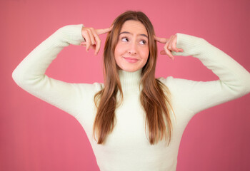 Fototapeta premium Young beautiful woman over isolated pink background and thinking with two fingers on her head very concentrated.
