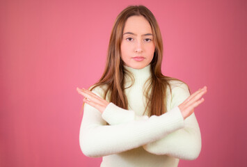 Serious beautiful woman showing cross stop gesture, frowning and telling no, prohibit action,...