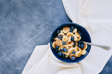 Close- up Mini Pancake cereal, mini pancakes in a dark blue bowl with sirup honey with blueberry