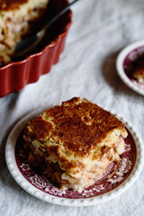 Apple and Cheese Cobbler Crisp. Cobbler or Crumble dessert with apples in ceramic baking form on beige linen table. Selective focus