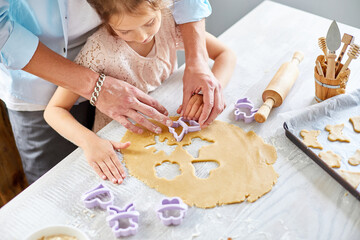 Father and daughter make cookies by mold