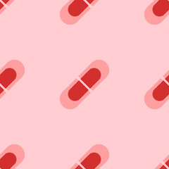 Seamless pattern of large isolated red medical capsule symbols. The elements are evenly spaced. Vector illustration on light red background