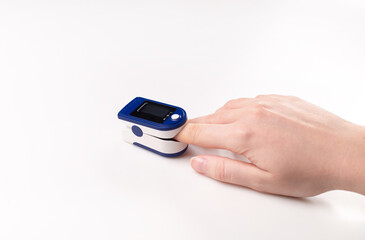 Pulse oximeter used to measure pulse rate and oxygen levels . Close up of Finger in an Oximeter Device. Pulse oximeter on white background.
