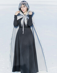 Fairy tale scene at arctic, woman in cold fantasy look, silver hair , cloak and dress at snowy day....