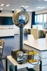 Van de Graaff generator:  an electrostatic generator which produces very high voltage direct current (DC) electricity at low current levels. Used as demonstration in physics class.