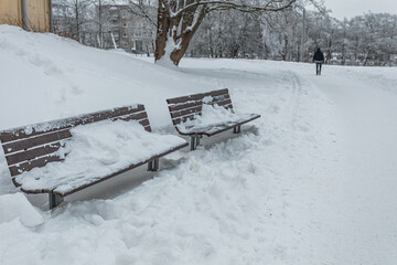 Benches in the snow in the park. Snowy winter concept.