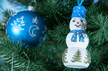 Christmas. Christmas toy snowman on a green branch of the New Year tree. 