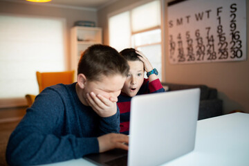 boy and girl looking at a laptop with a worried and confused look