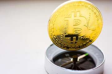 gold colored bitcoin coin on the compass case