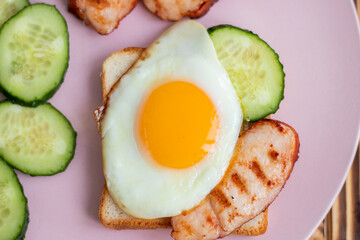  sandwich with egg, cucumber and bacon on a pink plate. healthy breakfast for one. beautiful food setting. High quality photo
