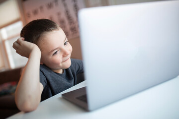 boy looking at a laptop with a worried and confused look