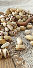 fried pistachios lie in a wooden menagerie scattered around on a wooden table and burlap