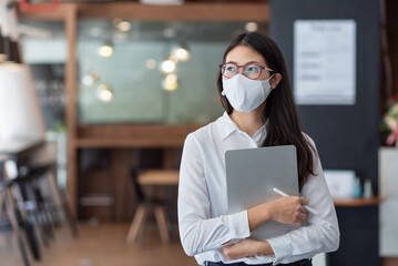 Asian business woman wear a mask to prevent COVID-19 at the office.