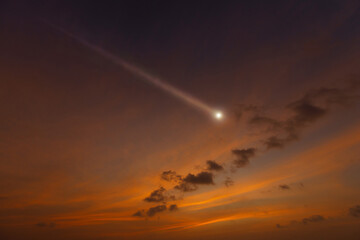 Bright shooting star in sunset cloudy sky