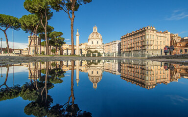 Fototapeta premium Rome, Italy - in Winter time, frequent rain showers create pools in which the wonderful Old Town of Rome reflect like in a mirror. Here in particular Via dei Fori Imperiali