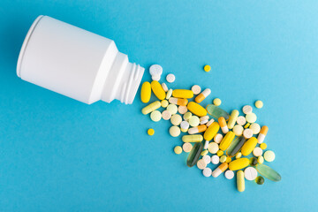 Bottle with colorfu medicine pills on color background. Medical concept. Closeup.