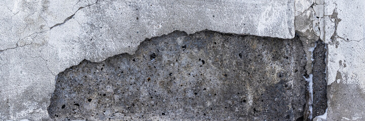 The texture of a cracked concrete house wall. Rough concrete surface. Wide panoramic background for design.