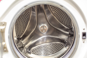 The washing machine drum is dry and clean close-up. Washer