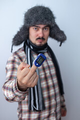 The man shows the middle finger with an oximeter. coronavirus concept