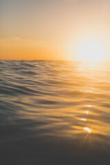 Smooth water texture at sunset with horizon