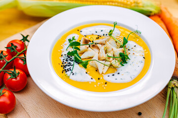 cheese soup with sesame seeds and herbs and vegetables on a decorated table