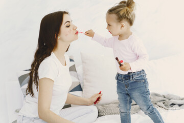 Family doing makeup and smiling. Mother with daughter at home.