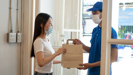 Parcel delivery workers wearing masks deliver products to customers who work at home during quarantine to prevent the COVID-19 outbreak.