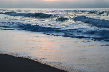 Cloudy sunset over the ocean and a little beach