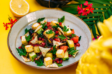 healthy food. Salad with zucchini, tomatoes, herbs and pomegranate seeds on a decorated table