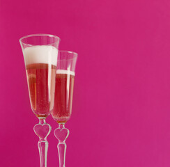 two glasses of champagne on  pink background