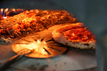 Neapolitan pizza with sausage in a wood-fired oven