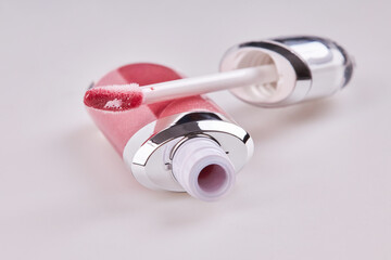 Tube of liquid lipstick gloss with applicator isolated on white background
