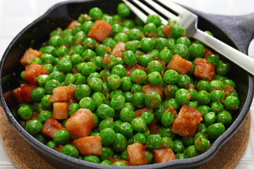 fresh green peas with ham in skillet