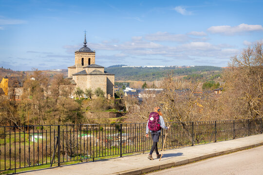 Pilgrim Girl with Hiking Gear Walking along Street Road in Molinaseca on Way of St James Camino de Santiago  Pilgrimage Trail in Spain