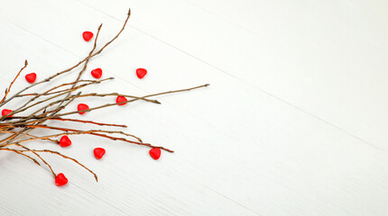 Red sweet hearts and tree branches on a wooden background. Valentine's day. Copy space