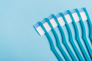 Top view of clean toothbrushes on blue background