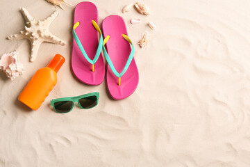 Different beach accessories on sand, flat lay. Space for text
