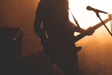 Silhouette of bass guitar player with microphone