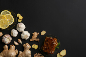 Ginger and other natural cold remedies on black table, flat lay. Space for text